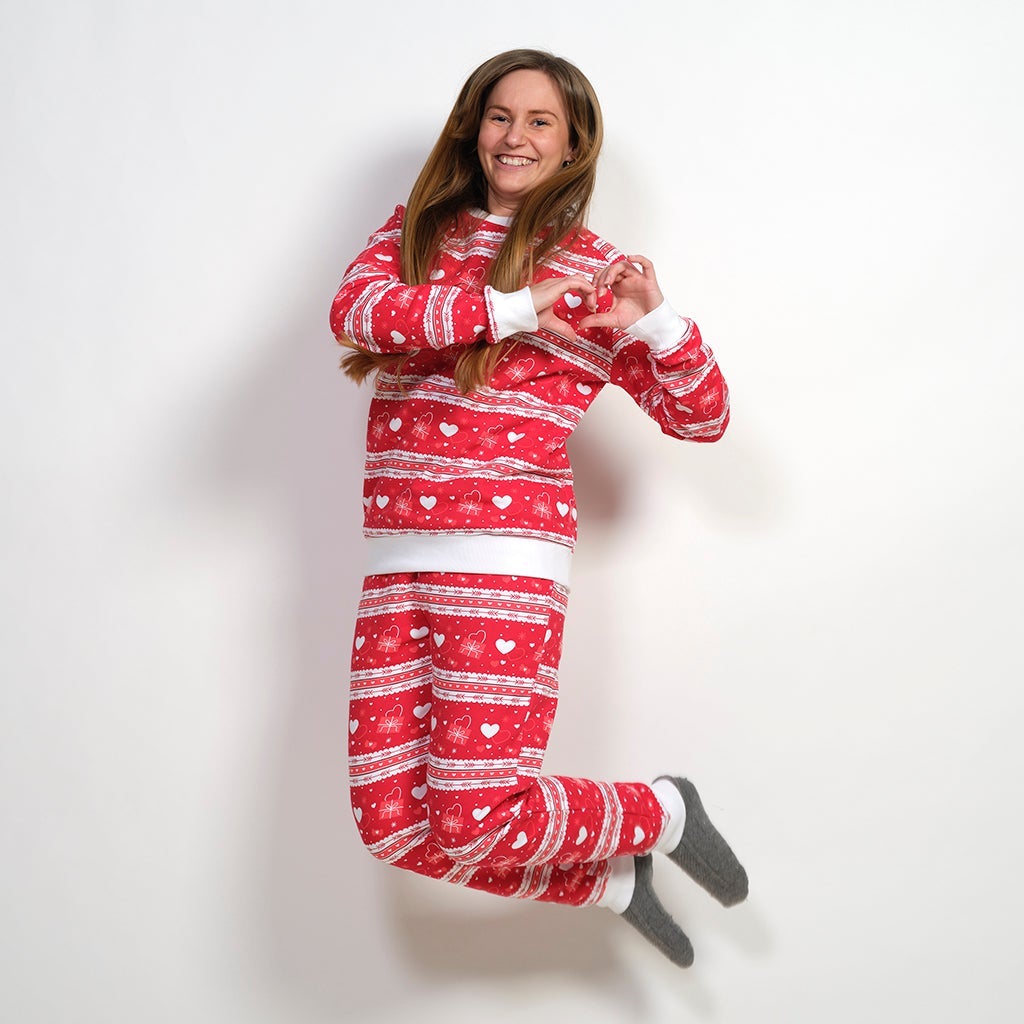 En studsande kvinna klädd i en röd alla hjärtans dag-jumpsuit.