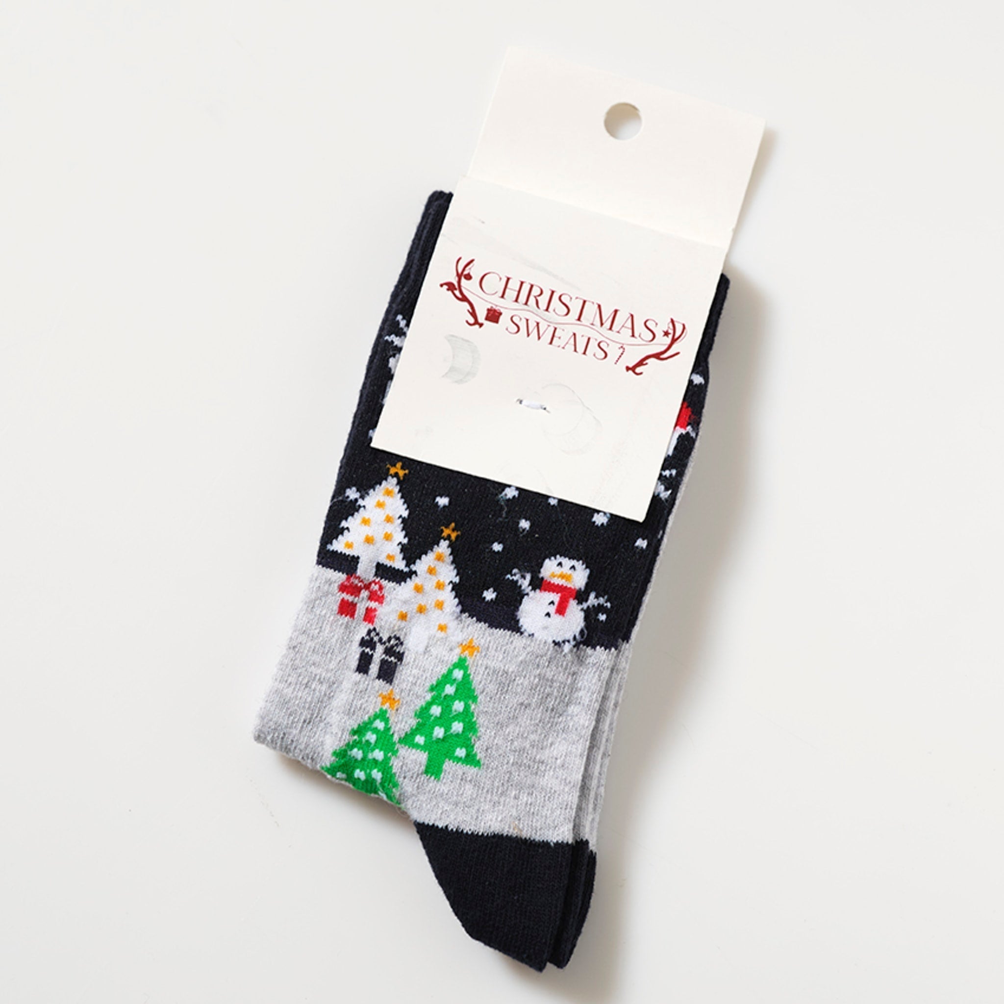 Ett par svarta julstrumpor med julgranar på.