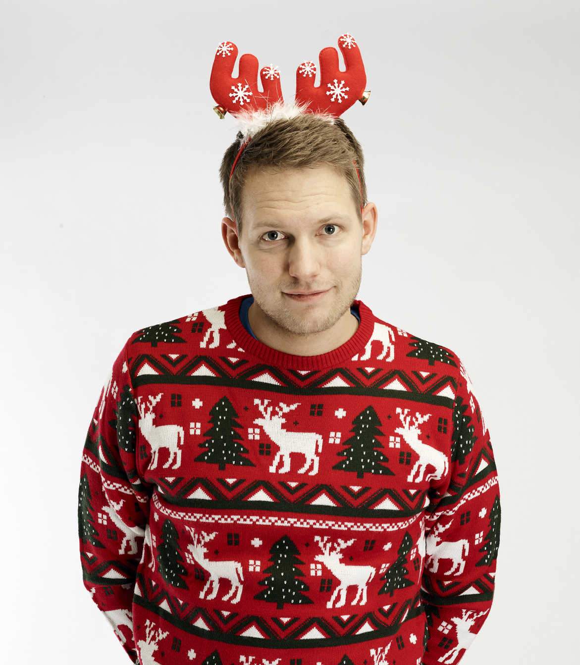 En poserande man med en röd hårinpackning som liknar ett renhorn.